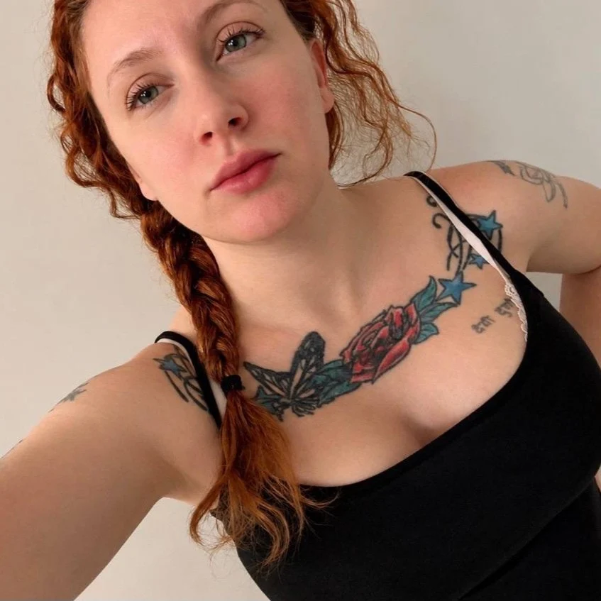 Maddy with braided red hair in a black top