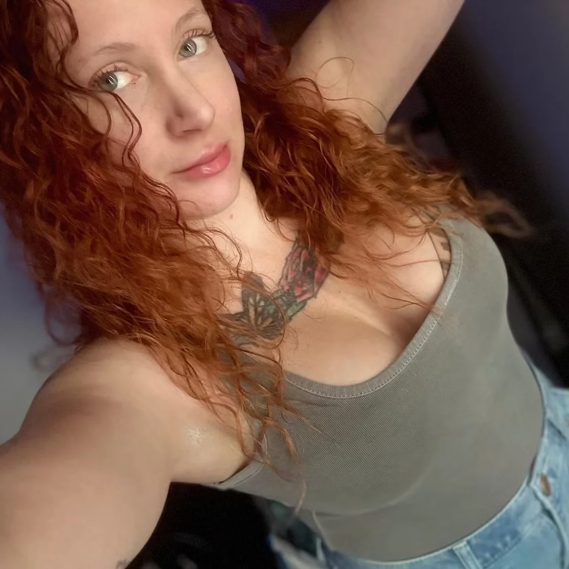 Maddy with red curls and a gray top