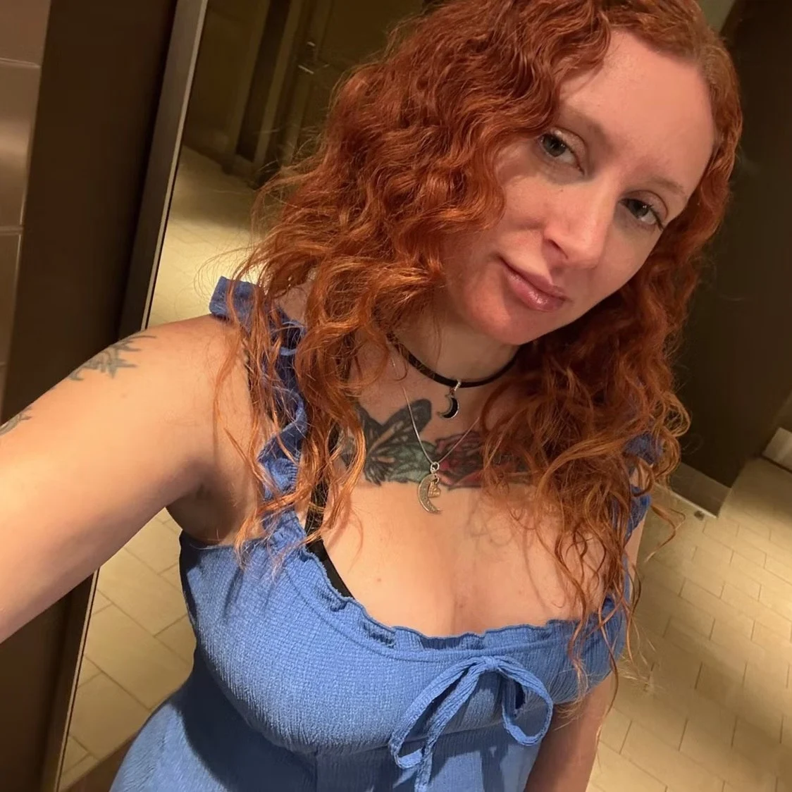 Maddy in a blue top with moon necklaces